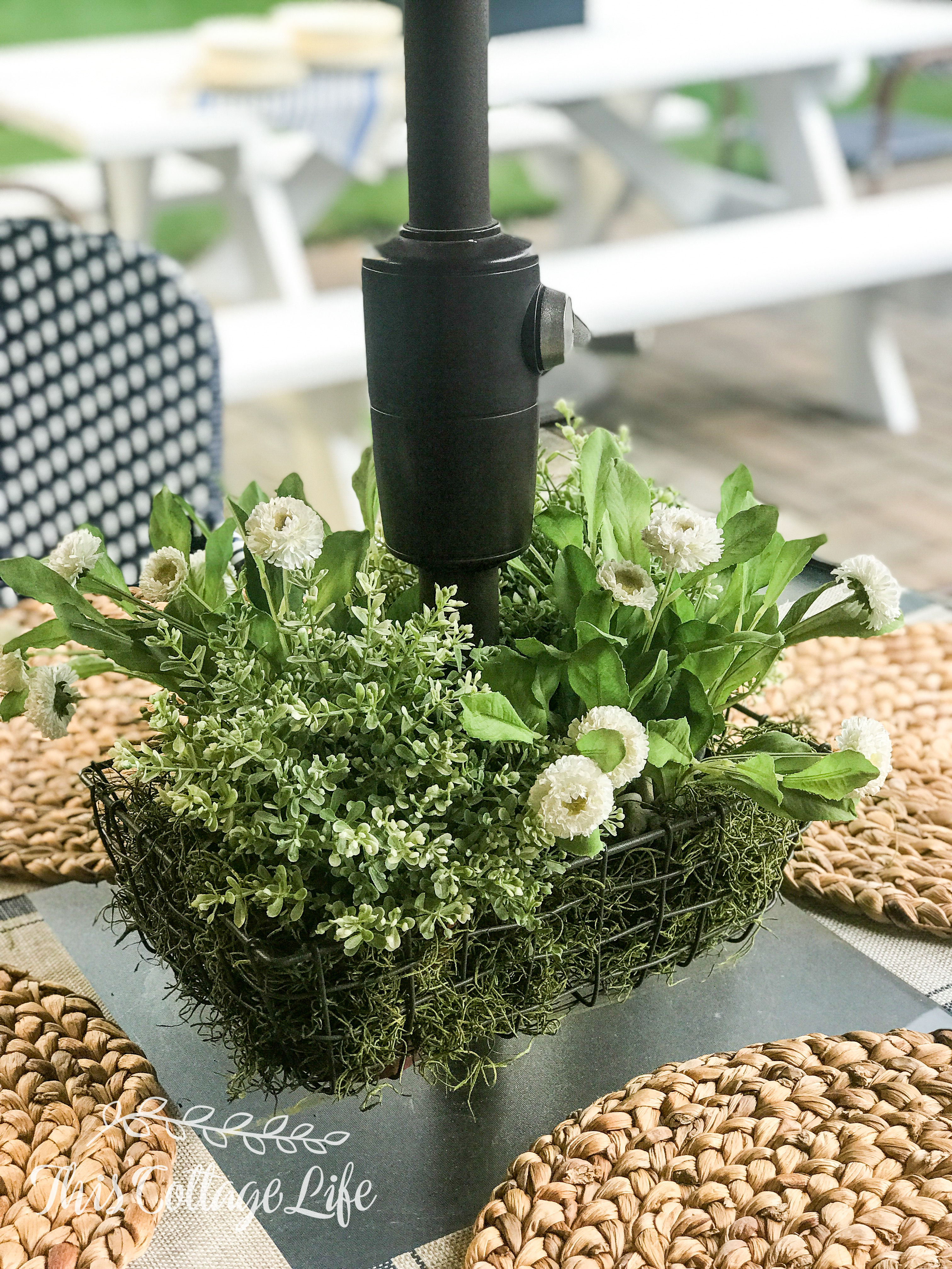 wire basket with faux foliage for centerpiece on patio umbrella table