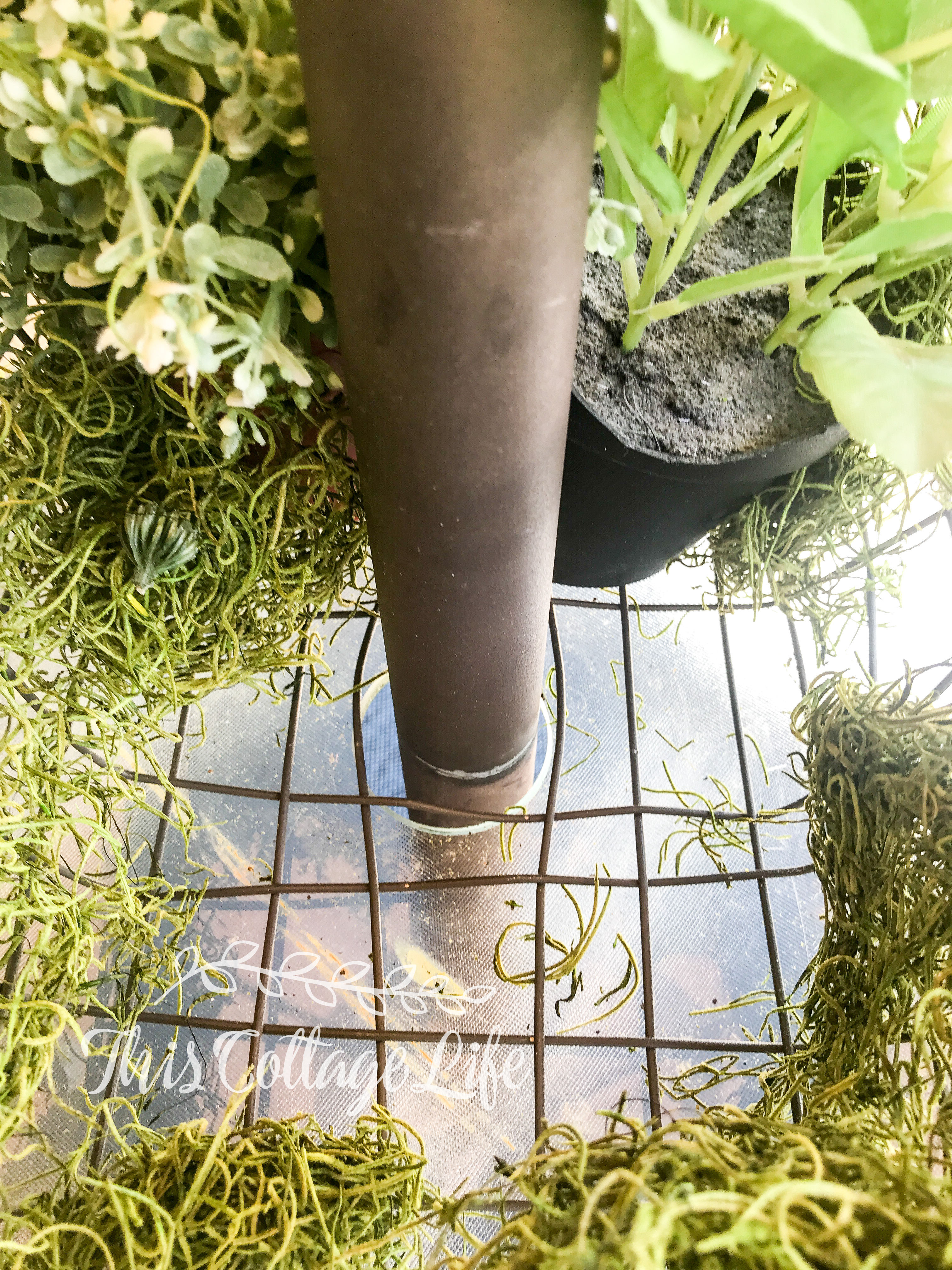 Use a wire basket from HomeGoods to make a centerpiece around umbrella pole on patio table