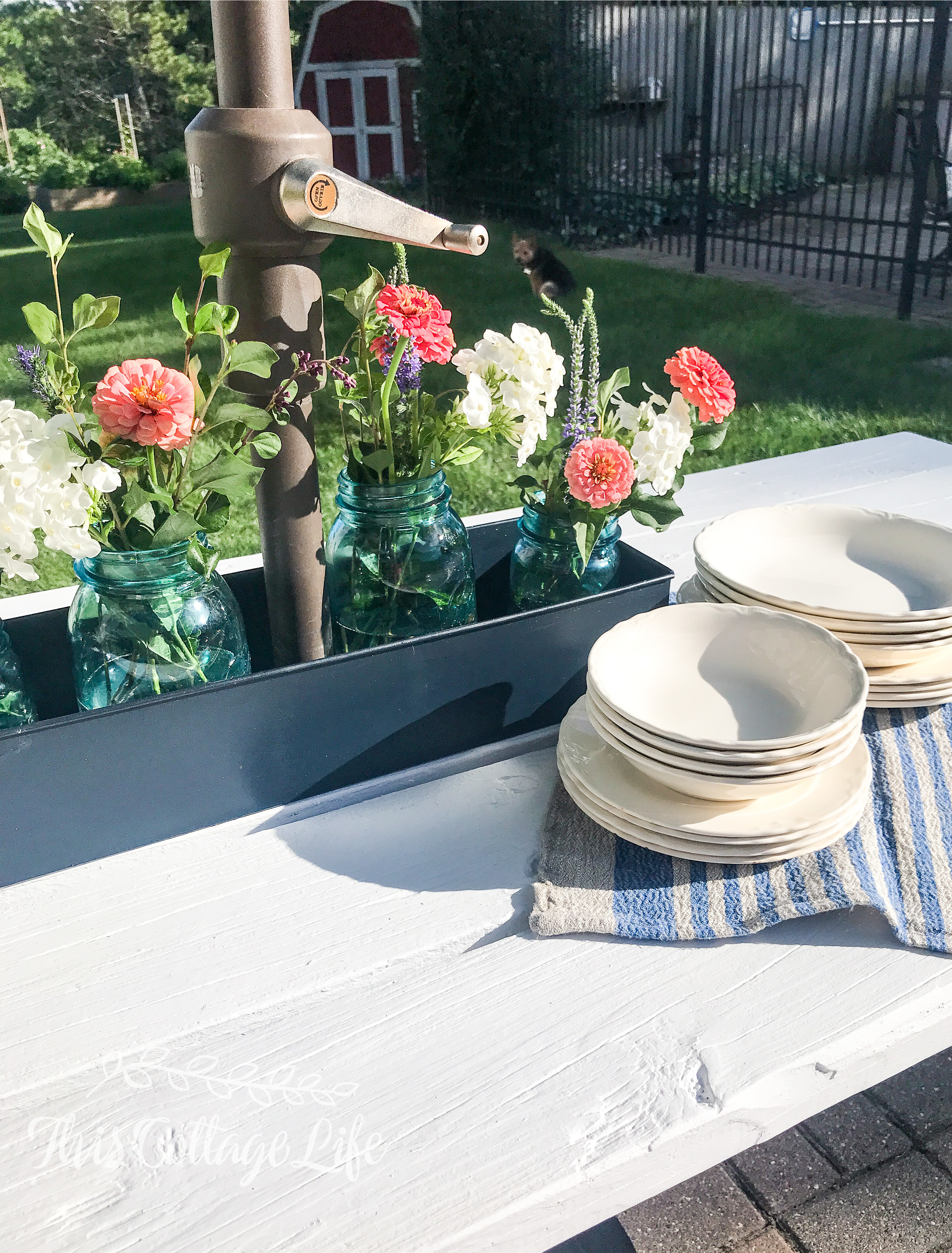 decorate patio table with metal box to hold mason jar flower arrangements