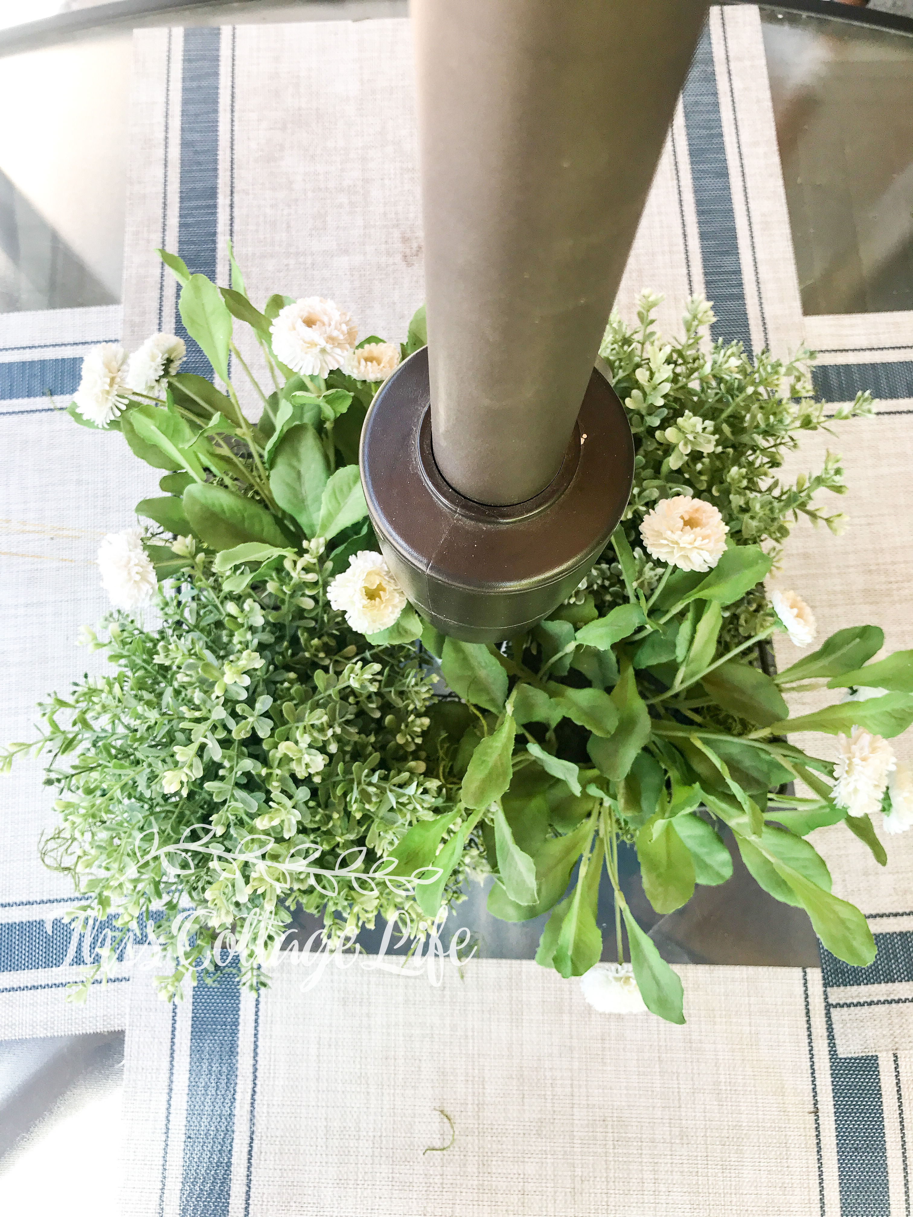 Ikea foliage and wire basket make a centerpiece for umbrella table 